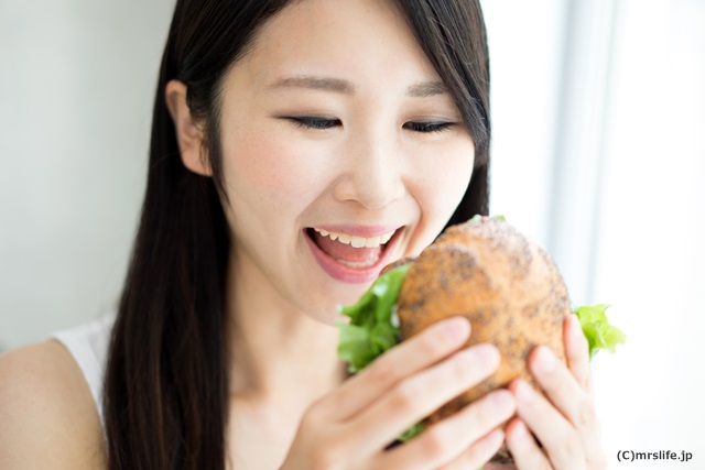 ハンバーガーを食べようとしてる女性