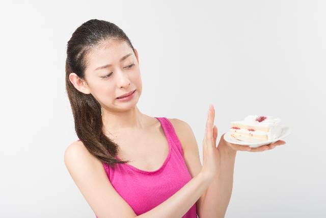 ケーキを我慢する女性