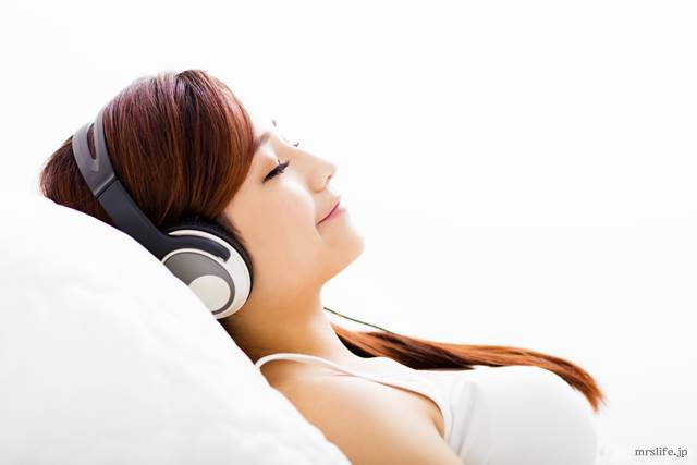 寝ながら音楽を聴く女性