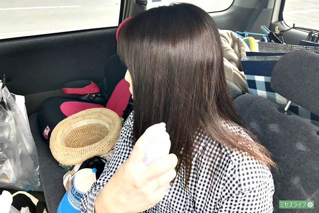 日焼け止めスプレーを髪に使う女性